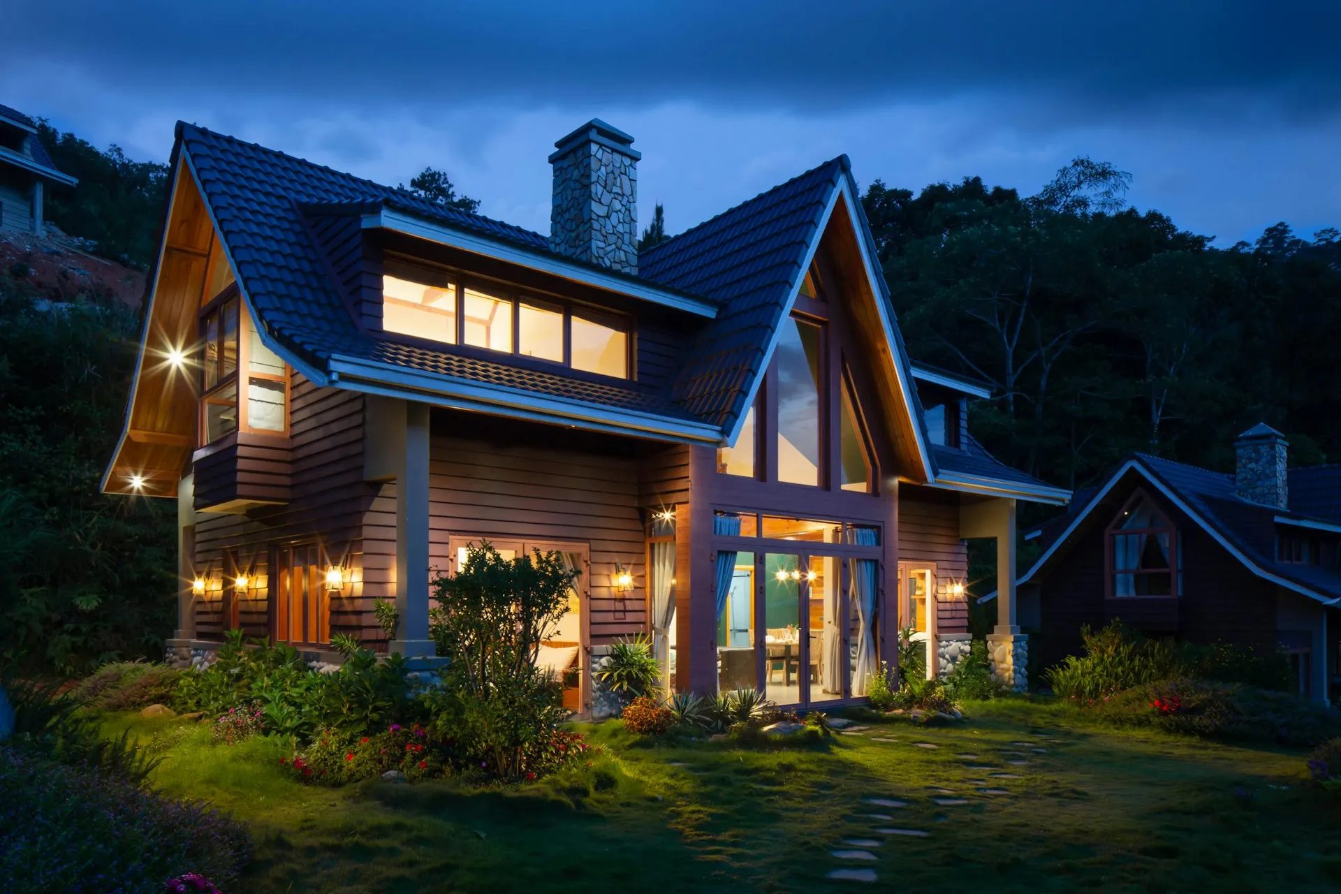 Mountain home with large energy-efficient windows glowing at dusk